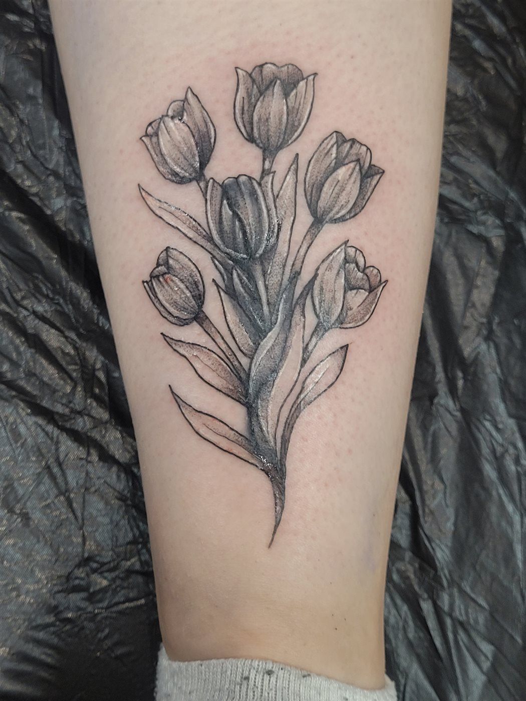 TULIPS tattoo — black & grey, calf — by Kayleigh Chaos, tattoo artist in Perth, Scotland