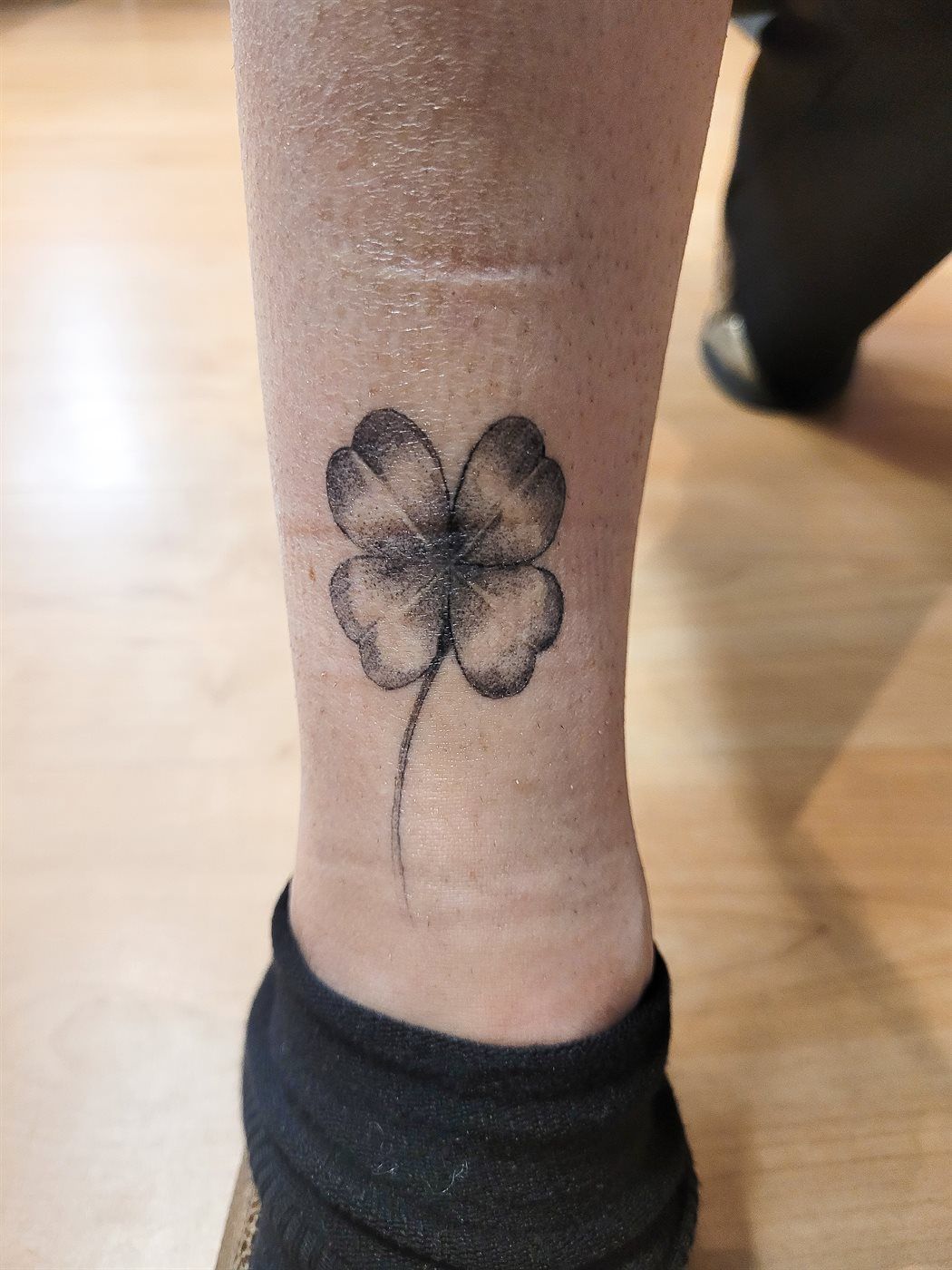 CLOVER tattoo — fine line, ankle — by Kayleigh Chaos, tattoo artist in Perth, Scotland