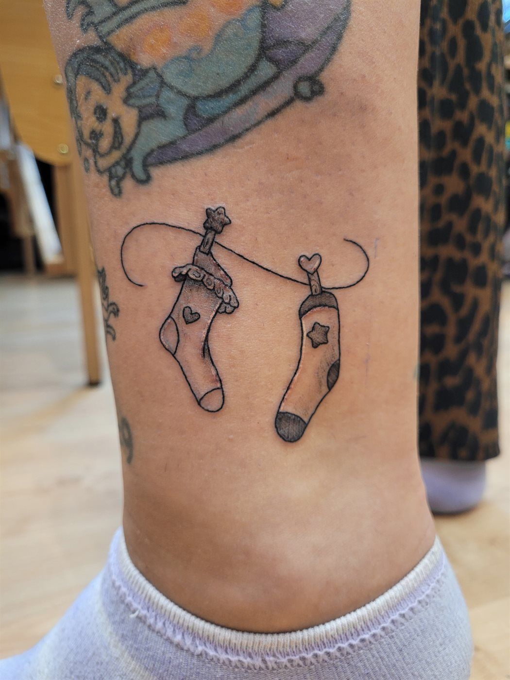 SOCKS tattoo — fine line, ankle — by Kayleigh Chaos, tattoo artist in Perth, Scotland