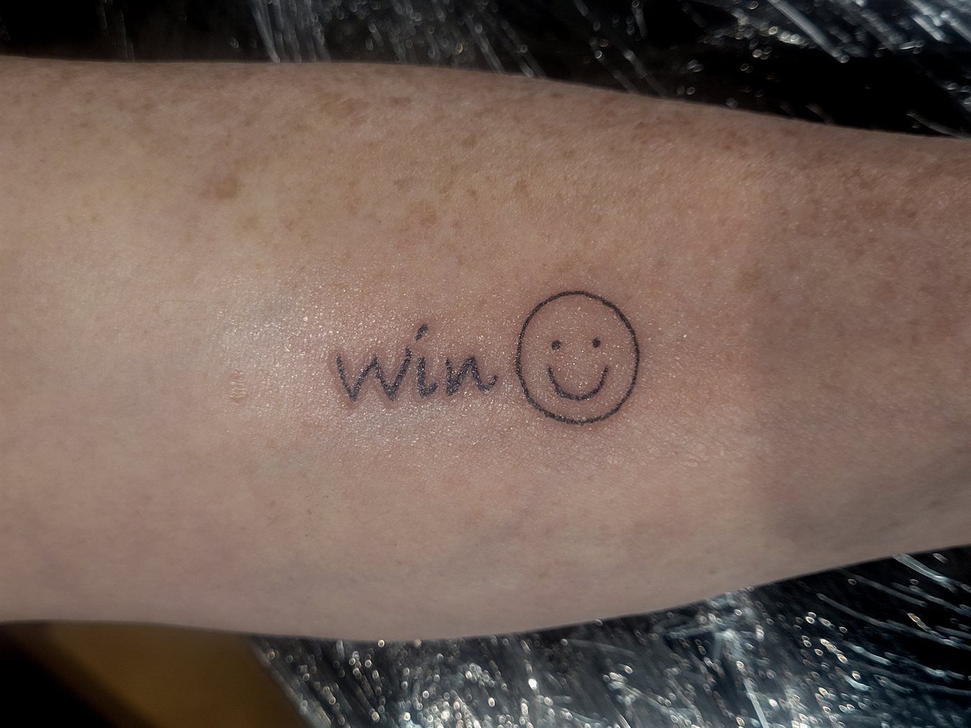 WIN ☺ tattoo — fine line, wrist — by Kayleigh Chaos, tattoo artist in Perth, Scotland