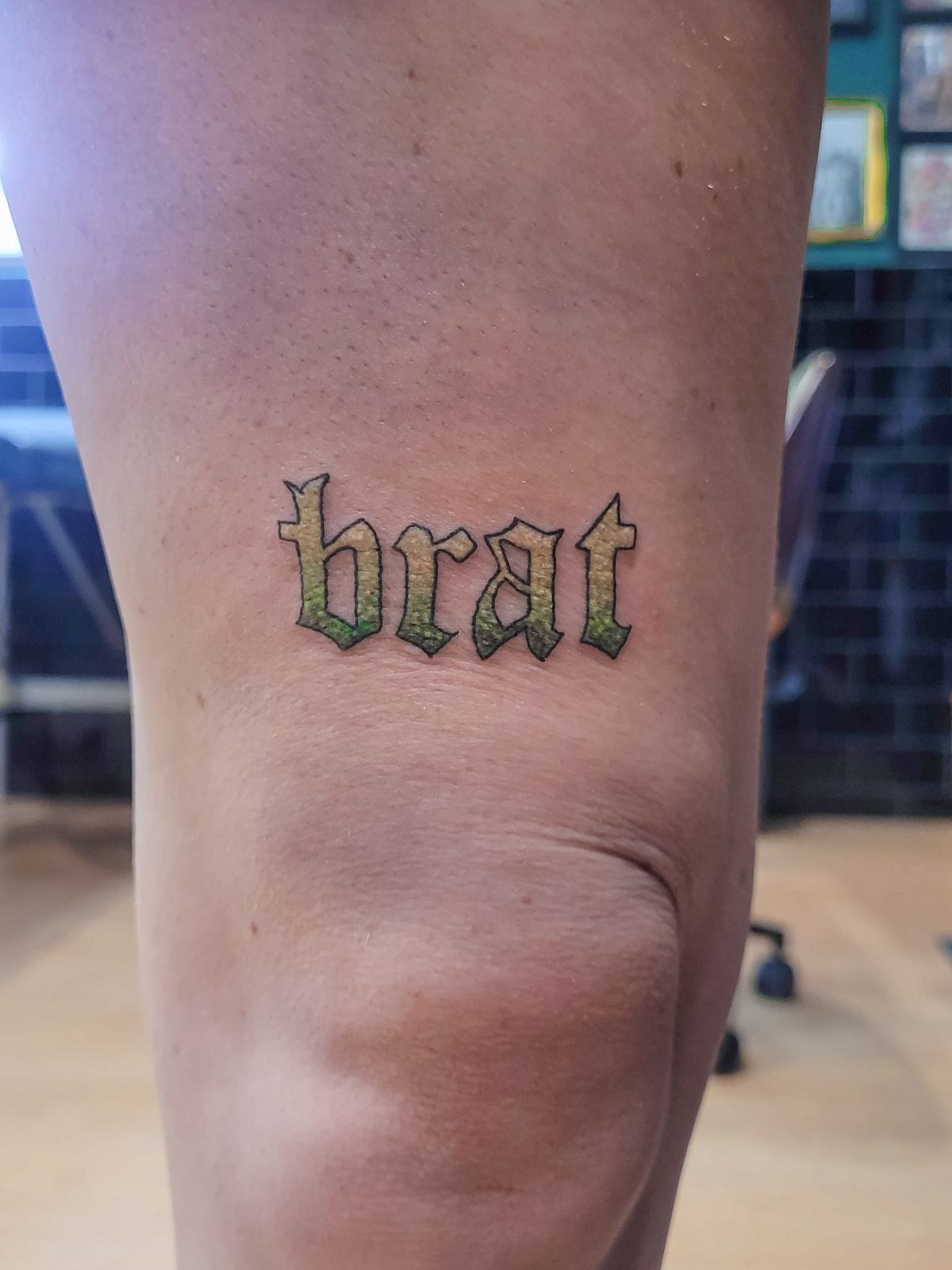 BRAT tattoo — glitter, knee — by Kayleigh Chaos, tattoo artist in Perth, Scotland