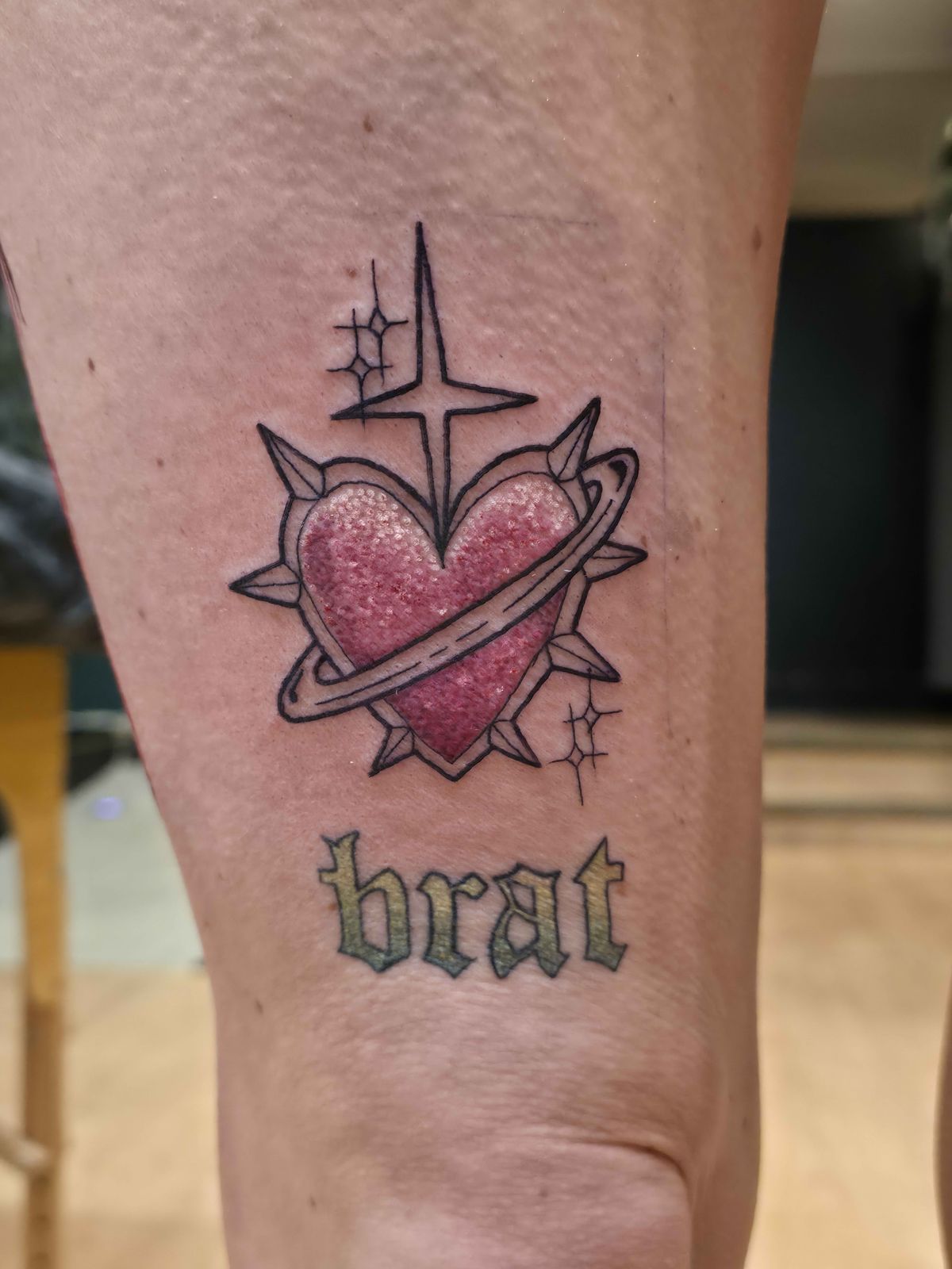 BRAT + HEART tattoo — glitter, thigh — by Kayleigh Chaos, tattoo artist in Perth, Scotland