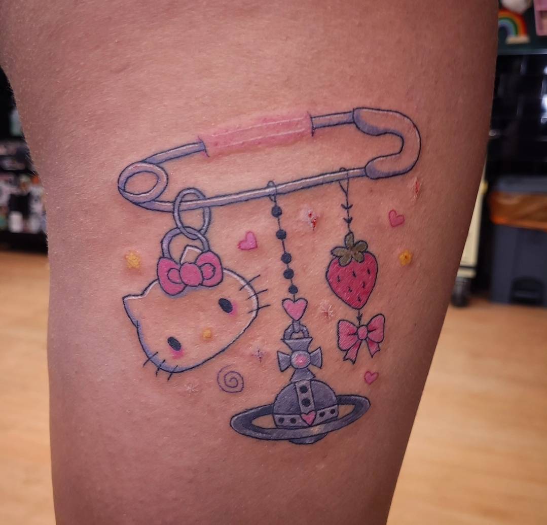HELLO KITTY SAFETY PIN tattoo — kawaii, thigh — by Kayleigh Chaos, tattoo artist in Perth, Scotland