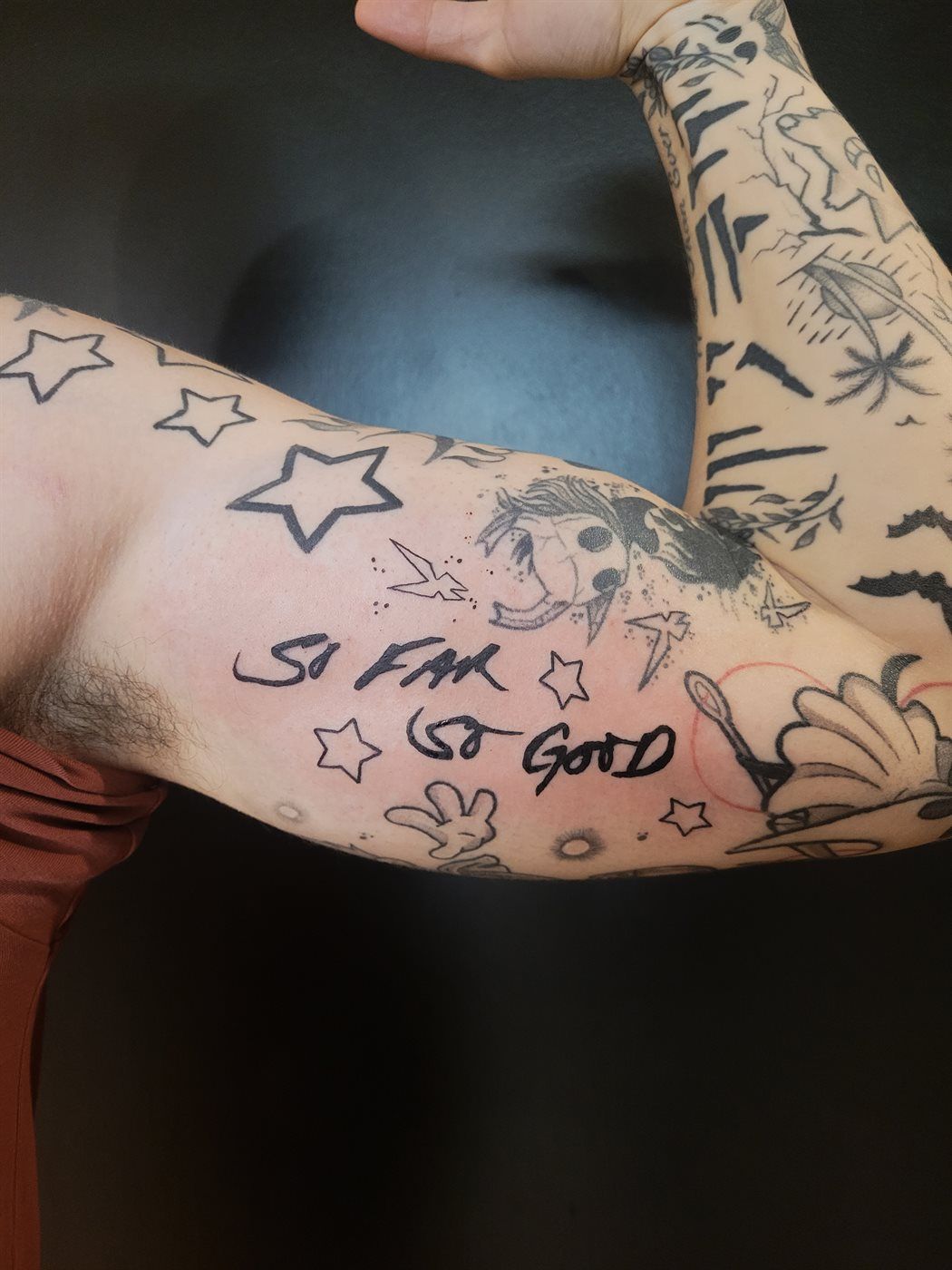 SO FAR SO GOOD tattoo — script, upper arm — by Kayleigh Chaos, tattoo artist in Perth, Scotland
