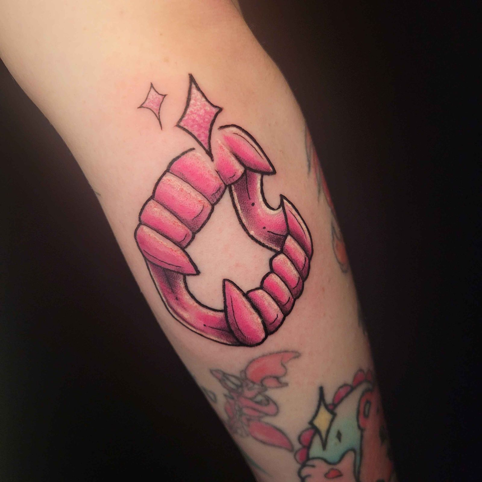 VAMPIRE FANGS — PINK tattoo — trad, arm — by Kayleigh Chaos, tattoo artist in Perth, Scotland